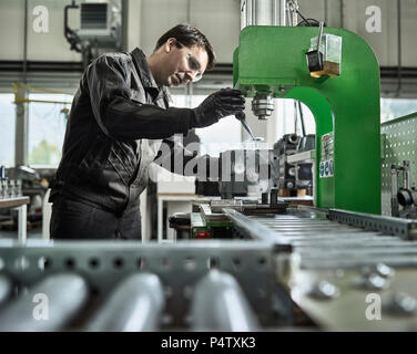 Worker in metalworking factory loading cylinder head Stock Photo