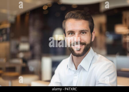Portrait of smiling young businessman in a cafe Stock Photo