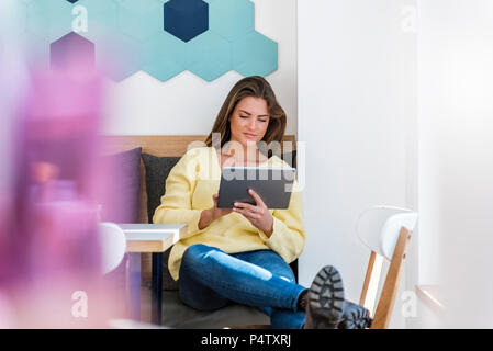 Relaxed young woman using tablet in a cafe Stock Photo