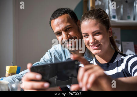 Happy couple taking a selfie in a cafe Stock Photo