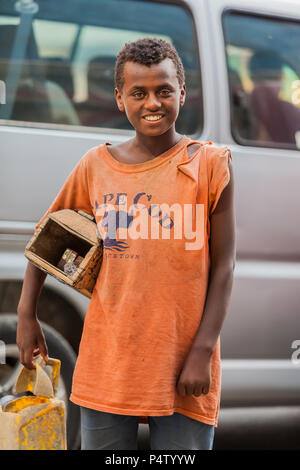 Addis Ababa, Ethiopia, January 27, 2014, Young teenager working as a shoe shine boy on the street, looking straight at the camera Stock Photo