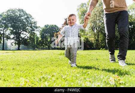 Father walking hand in hand with son, rear view Stock Photo - Alamy