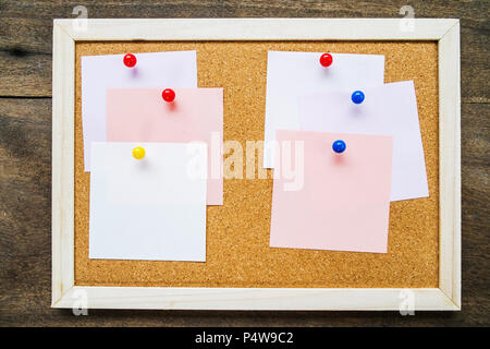 Sticky note on cork board on wooden wall background,empty space for text. Stock Photo