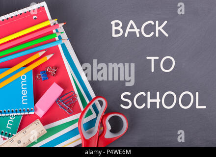 School supplies on a chalkboard background with BACK TO SCHOOL text Stock Photo