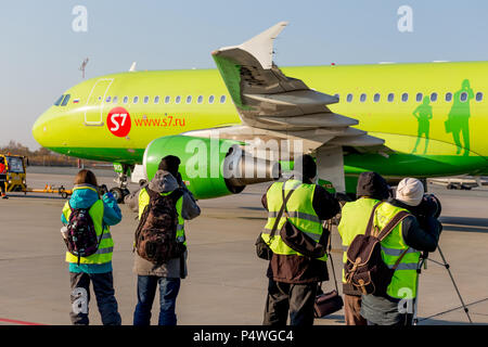 Russia, Vladivostok, 10/13/2017. Photographers make photos of plane on runway. Airbus A320 of S7 Airlines. Plane spotting, hobby, aviation. Stock Photo