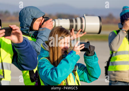 Russia, Vladivostok, 10/13/2017. Photographers makes photos with smartphone and modern digital camera with big telephoto lens on event outdoor. Stock Photo