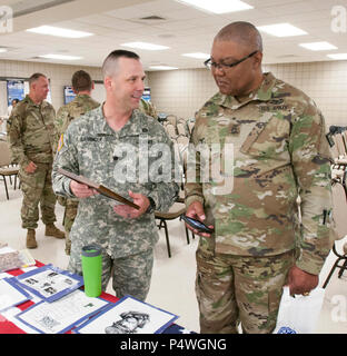 ROBINSON MANEUVER TRAINING CENTER, N. Little Rock, Ark.:—Lt. Col. Richard Garringer (left) and Master Sgt. Dishoungh White look at an exhibit duirng the Arkansas National Guard Equal Opportunity Office Diversity Day at Chappell Armory, Wednesday, May 10, 2017. The event was an opportunity to celebrate the diversity of the Total Force and embrace who we are and who we aren't regardless of race, gender, nationality, religion, or disability. More than 70 Soldiers were provided with information about diversity, a taste of cultural entertainment and ethnic foods and displays with information about  Stock Photo