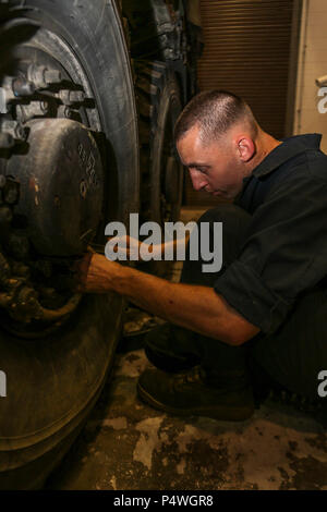 U.S. Marine Corps Lance Cpl. Christopher Bouma, Automotive Maintenance Technician, 2nd Transportation Support Battalion (TSB), Combat Logistics Regiment 2, 2nd Marine Logistics Group, repairs a tire on a Rough Terrain Container Handler during a gear serviceablity inspection on Camp Lejeune, N.C., May 9, 2017. 2nd TSB conducted the inspection to ensure gear was ready to support Command Post Exercise III. Stock Photo