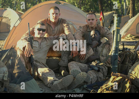 MOUNT BUNDEY TRAININIG AREA, Australia -- U.S. Marines Cpl. Sean Pierson, (top left), Cpl. Blake Adire, (bottom left), Sgt. Reid O'Hala, (top right), and Lance Cpl. Daryl Thomas with Company K 3rd Battalion, 4th Marine Regiment, 1st Marine Division, Marine Rotational Force Darwin, pose for a photo after a long day of training, May 9, 2017.   These Marines are currently refining there tactical proficiencies in the bush as a team in preparation for Exercise Predator Run.  “It’s hot out here, but we’re used to that coming out of Twentynine Palms. By the time we’re done with this exercise there’ll Stock Photo