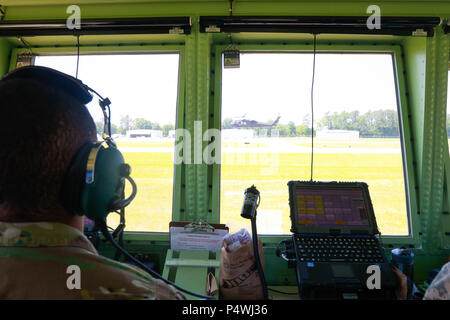 A Soldier form 2nd Battalion Airfield Operations, 130th Aviation Regiment, observes a UH-60 Black Hawk helicopter from an air traffic control tower during combined readiness exercise while honing on skills by providing airspace and air traffic services support during a joint readiness exercise at Harnett Regional Jetport, N.C., May 10. Stock Photo