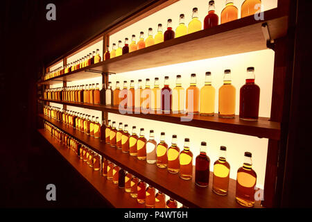 Whiskey bottles in rows on display shelf Stock Photo