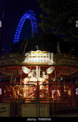 Pleasure Children's Fairground traditional Carousel ride with London Eye in the background during the evening, London, England, UK. Stock Photo