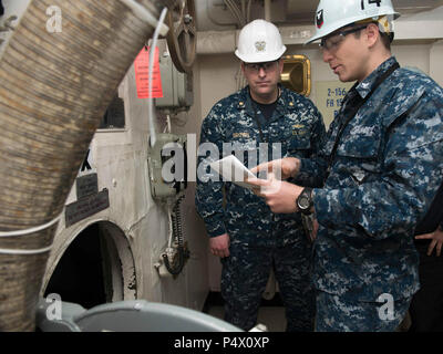 Washington (May 10, 2017) Lt. Cmdr. Michael Brown, USS John C. Stennis’ (CVN 74) damage control assistant, from St. Louis, conducts a maintenance spot check with Machinist's Mate 3rd Class Sam Anthony, from Lexington, North Carolina, on an escape scuttle aboard John C. Stennis. Spot Checks ensure maintenance is being performed correctly. John C. Stennis is conducting a planned incremental availability (PIA) at Puget Sound Naval Shipyard and Intermediate Maintenance Facility, during which the ship is undergoing scheduled maintenance and upgrades. Stock Photo