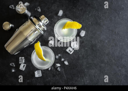 Alcohol Cocktail with lemon and ice. Gin tonic fizz or gimlet cocktail on black background, copy space. Stock Photo