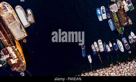 Group of Old Cargo Ships, Tugboats, Fishing Ships and Small Boats in the Coast near Rocks. Transportation. Stock Photo