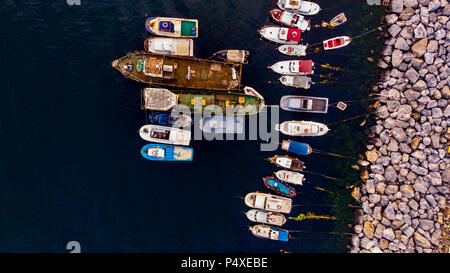 Group of Old Cargo Ships, Tugboats, Fishing Ships and Small Boats in the Coast near Rocks. Transportation. Stock Photo