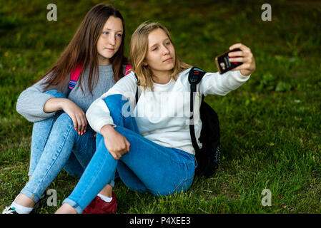 Two girl friends schoolgirl. Summer in nature. Girls hold each other's ...