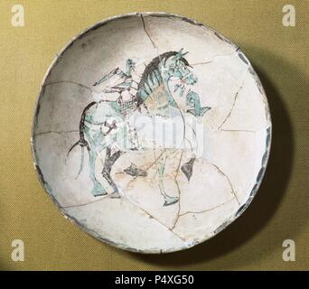 Islamic pottery. Taifor. Plate decorated with horse. Ceramic glaze. From Medina Elvira (Granada). 10th century. Archaeological Museum of Granada. Andalucia. Stock Photo