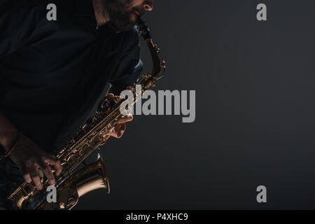cropped shot of jazzman playing saxophone on black Stock Photo