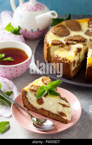 The concept of breakfast or relaxation. Chocolate New York cheesecake and mint tea cup on concrete background. Stock Photo