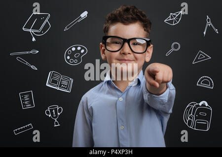 Cheerful boy pointing at young and smiling happily Stock Photo