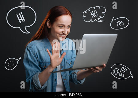 Happy student smiling while having a video call with her parents Stock Photo