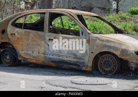 Burned car parked on the street side view - Close up photo of a burned out car Stock Photo