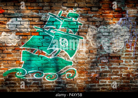 Bologna, Italy, 20 April 2018 - Graffiti artwork from unknown author on a red brick wall depicting a green vessel in the waves and clouds with the sym Stock Photo