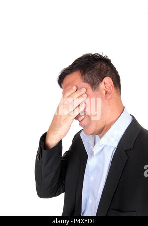 A close up image om a businessman in profile in a suit covering his face, suffering from pain, isolated for white background Stock Photo