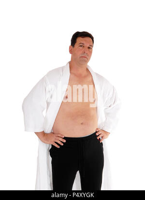A handsome man standing in a white bathrobe and without shirt with his hand on his hips, isolated for white background Stock Photo