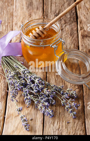 Healthy food: floral lavender honey in a glass jar close-up on a table. vertical Stock Photo