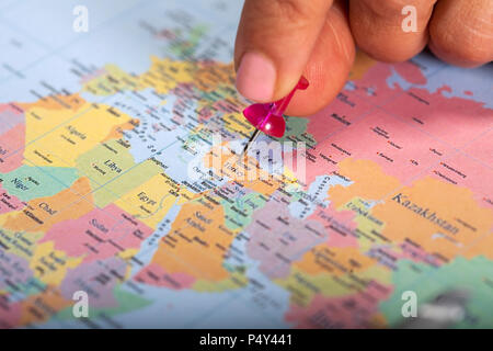 Hand marking Turkey on map with red pin Stock Photo