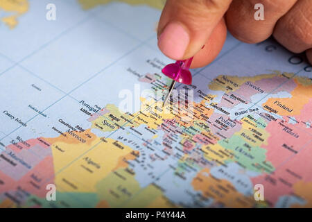 Hand marking Paris on map with red pin Stock Photo