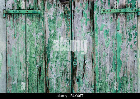 Old green painted wood door for background. Vintage background from a wooden shabby plank with metal lock. Wood texture. Background old panels. Copy s Stock Photo