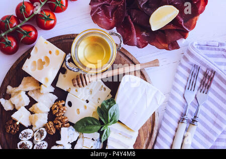Table full of mediterranean appetizers, tapas or antipasto. Assorted Italian food set. Delicious snack on party or picnic time. Chopping board with me Stock Photo