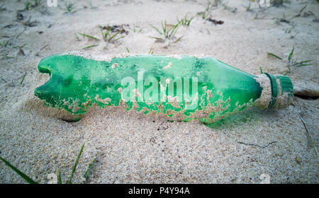 Empty single use plastic bottle washed up on beach Stock Photo