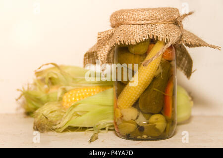 pickled corn and other vegetables in a jar Stock Photo