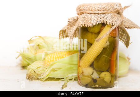 pickled corn and other vegetables in a jar Stock Photo