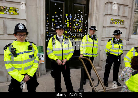 London, UK. 23rd June 2018. Police protecting the doors to the Cabinet Office in Whitehall after they had been festooned with anti-Brexit stickers - March for a Peoples Vote.  Credit: Scott Hortop/Alamy Live News.
