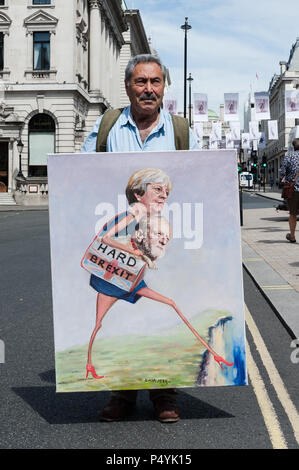 London, UK. 23rd June, 2018. Satirical artist Kaya Mar poses with his new artwork depicting Prime Minister Theresa May and Labour Party Leader Jeremy Corbyn walking towards a cliff edge. Tens of thousands of anti-Brexit supporters are expected to take part in People's Vote march in central London followed by a rally in Parliament Square on a second anniversary of the Brexit referendum. Demonstrators demand that the final terms of the Brexit deal negotiated by the government are put before British citizens in a public vote Credit: Wiktor Szymanowicz/Alamy Live News Stock Photo