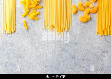 Variety of types and shapes of dry Italian pasta - Spaghetti, Linguine, Conchiglie, Elbow macaroni, Fusilli. Stock Photo