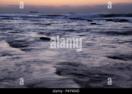 Durban, KwaZulu-Natal, South Africa, seascape, ships on horizon, daybreak, view of Indian ocean, breaking waves, Umhlanga Rocks beach, blur, landscape Stock Photo