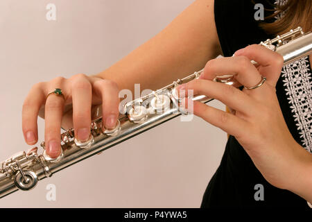 Flute in playing position showing fingers on keys Stock Photo