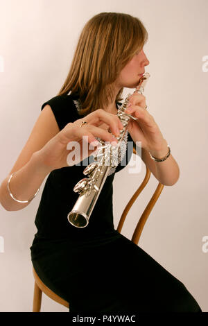 Flute in playing position showing fingers on keys and embouchure Stock Photo