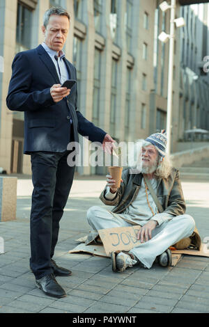 lderly rich businessman giving some money to poor man Stock Photo