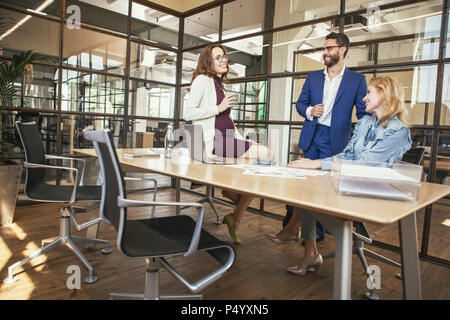 Optimistic three colleagues enjoying work Stock Photo
