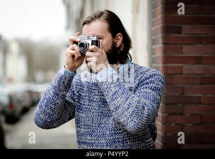 Man with beard taking pictures with old camera Stock Photo