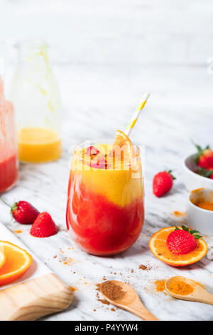 Strawberry and orange smoothie with curcuma and cinnamon on marble Stock Photo