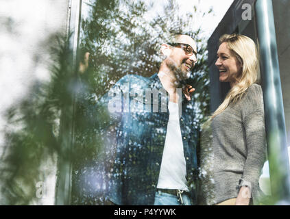 Laughing mature couple standing on terrace of their house Stock Photo