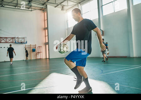 Indoor soccer player balancing the ball Stock Photo